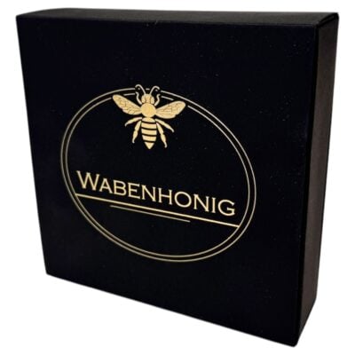 Wabenhonig in schwarzer Verpackung mit Bienen-Logo.