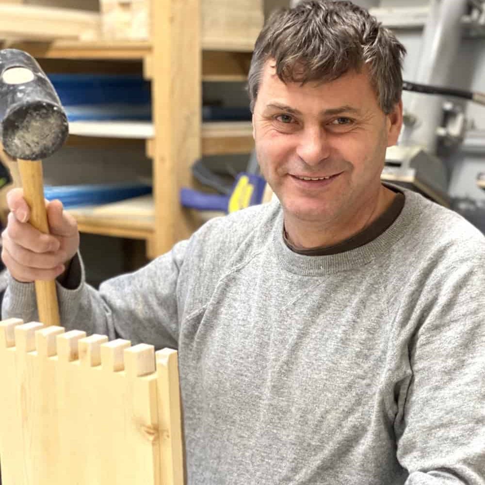 Mann mit Hammer bei Bienen Janisch, Imkerei und Honigproduktion.